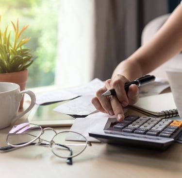 a woman is sitting at a desk with a calculator