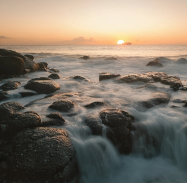 Sunrise over ocean waves on rocky shores in Albion, Mauritius