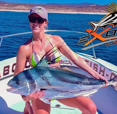 a woman in bikinis holding a fish on a boat