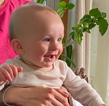 a nine month old smiling baby