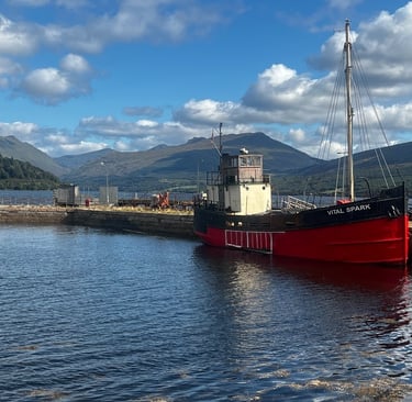 a boat docked at a pier with hills in the background
