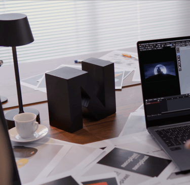 A person sitting at a desk with a laptop computer showing 3D animation software - Neopixel Digital
