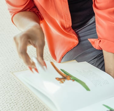 a woman and chil sitting on the floor reading a book