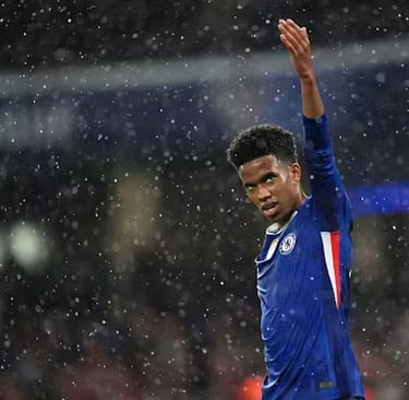 a man in a blue shirt is holding a soccer ball