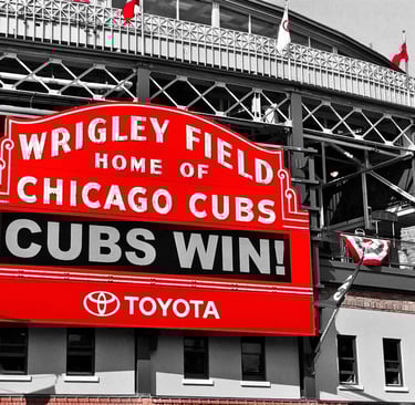 a large red and white sign that says cubs win at wrigley field