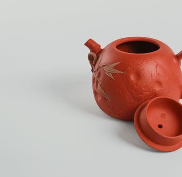an teapot and its lid against a gray-white background.