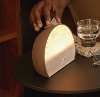 Hatch Restore 3 smart sunrise alarm clock in Putty fabric on a modern nightstand.
