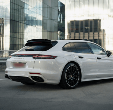 an Enlab white porsche panamera parked in front of a building