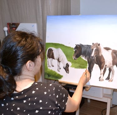 a woman is painting a picture of ponies