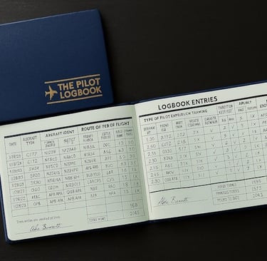 Open blue pilot logbook on black desk, filled with handwritten flight entries and aircraft details