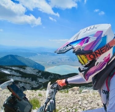 Freiheit und Fokus – Profilansicht auf dem Motorrad vor Berg- und Seekulisse