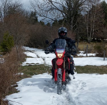 a man riding a motorcycle through the snow
