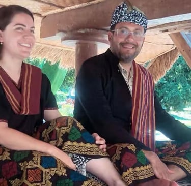 a man and woman sitting on a couch using Tradisional Suku Sasak clothes