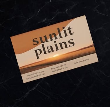 Business card with “Sunlit Plains” branding sits on polished black marble benchtop
