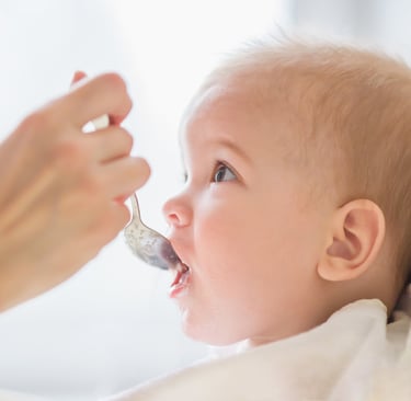 a baby gets food from a spoon