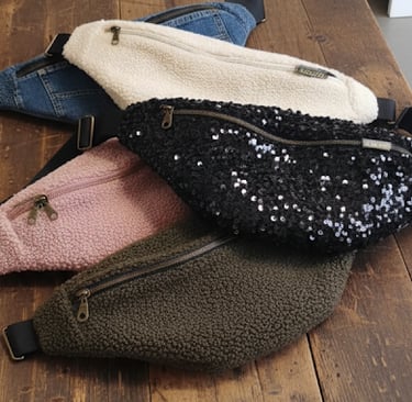 plusieurs sacs bananes lilyboo faites main de diferentes couleurs posés sur une table