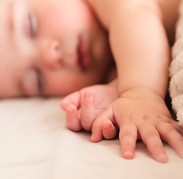 a baby is laying on a bed with a blanket