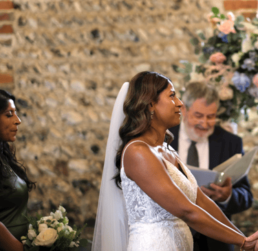A bride and groom holding hands in a barn