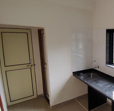 Spacious kitchen overlooking a jungle trail at Lakefield Apartments in Igatpuri