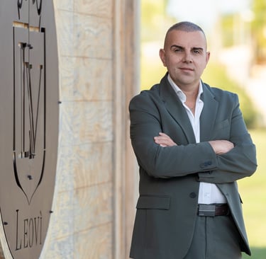 a man in a suit and white shirt standing in front of a clock