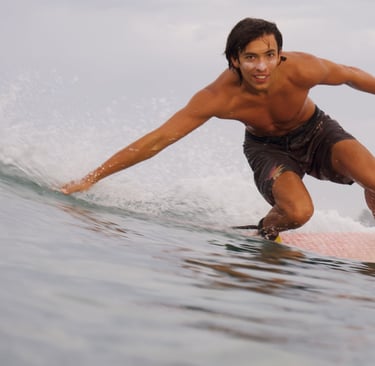 man riding surfboard looking into camera