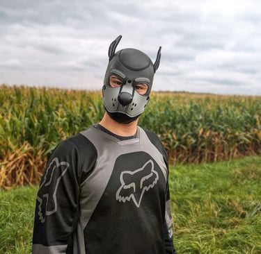 A man in a cornfield wearing a pup mask.