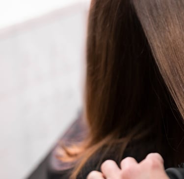 a woman is blow drying her hair in a salon