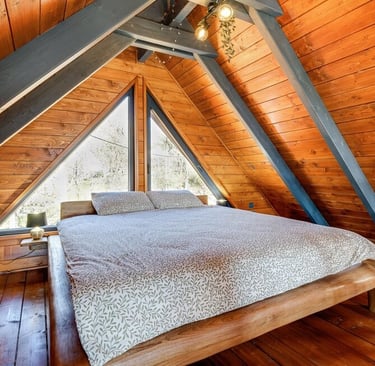 a bed in a loft apartment with a wooden floor