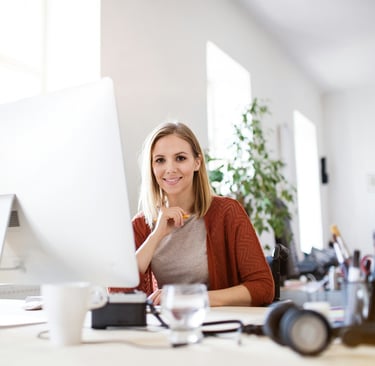 Young professional administrative assistant at her desk in her office.