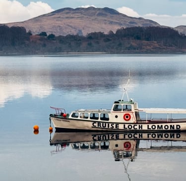 a boat in the water will hills in the background