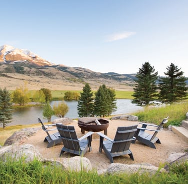 fire pit and chairs overlooking a lake