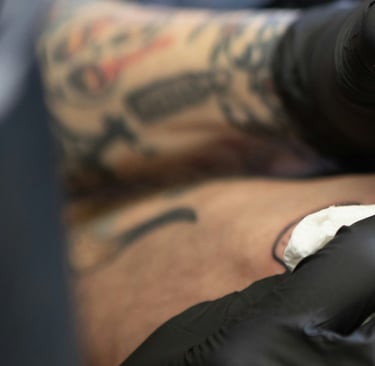 Tatuador desenvolvendo sua arte no braço de um cliente