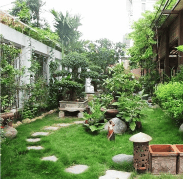 a garden with a stone path and a statue of a man