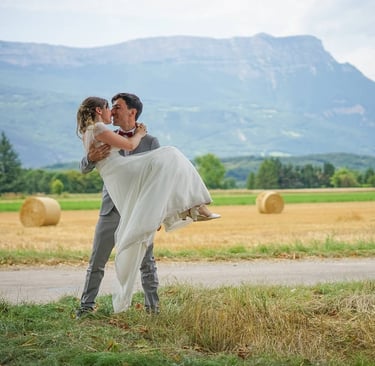 Photo de mariage, le marié porte la mariée dans ses bras dans un champ