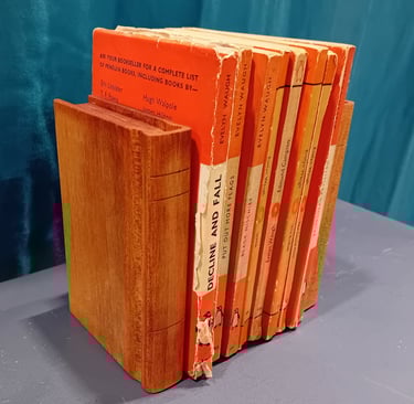 Pail of book-shaped wooden bookends around a set of orange books