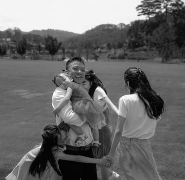 a family of four people standing around a woman holding a baby