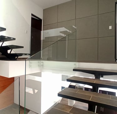 escalera panorámica que conecta los 3 niveles con barandal en cristal