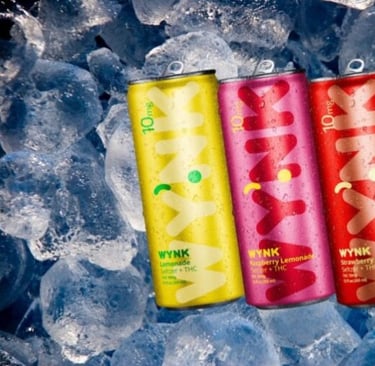 three cans of pink lemonade on ice