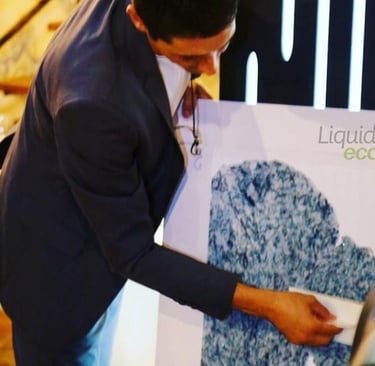 HOMEM DE TERNO ESCURO APLICANDO O PAPEL DE PAREDE LIQUIDO COM A BASE DE PVC BRANCO COM A LOGO