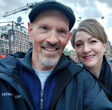 man and woman in front of buildings in amsterdam