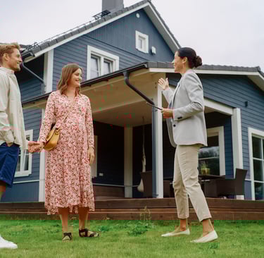 a man and woman standing in front of a house