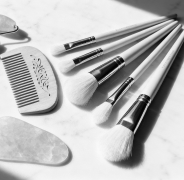 A curated GWP set of beauty tools: facial roller, Gua Sha, and comb.