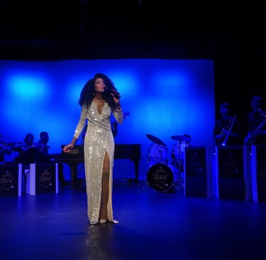 a woman in a gold dress standing in front of a stage