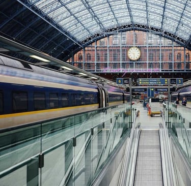 trains waiting on a platform at a large station