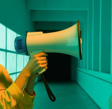A woman using a megaphone to amplify her voice, representing audiobook narration and the AI vs human
