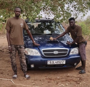 Teamleden van Birding Adventures Gambia & Senegal poseren bij een blauwe Kia safari-auto, gebruikt v