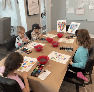 Young students working on watercolor circle paintings in Kelley’s Neighborhood Art class