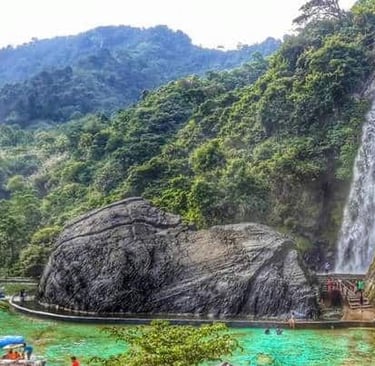 Air terjun Curug Bidadari setinggi 55 meter mengalir deras di Sentul Paradise Park, dikelilingi bebatuan besar dan jembatan i