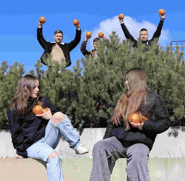 jauni zmones prie pusu stovi su apelsinais