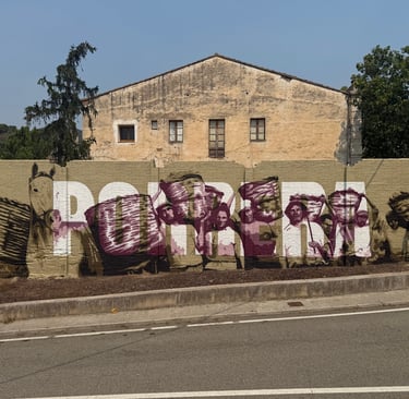 Mural de gran formato sobre fachada urbana realizado con aerosol. Representación figurativa que comb